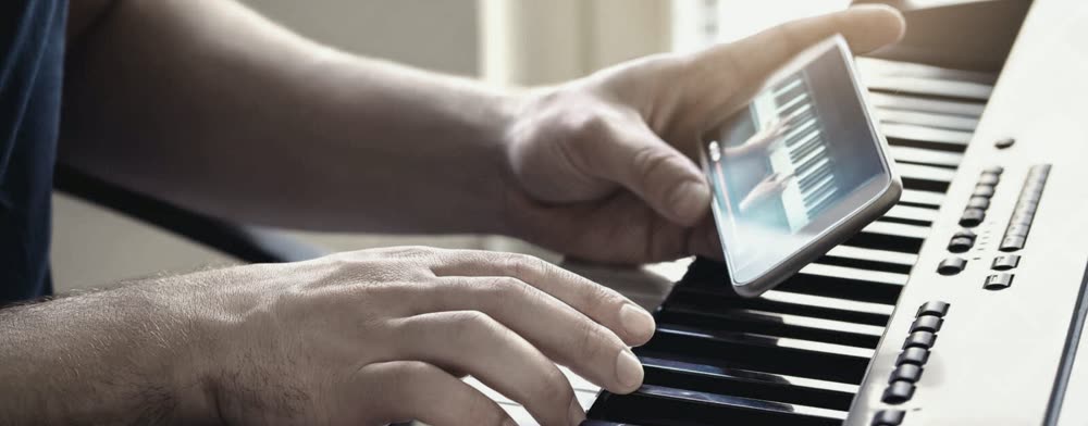 Juggling a phone tutorial in one hand while trying to play the keyboard with the other